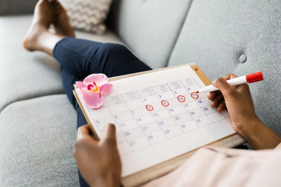 woman tracking menstrual cycle with calendar